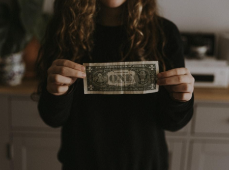 Woman holding a $1 bill